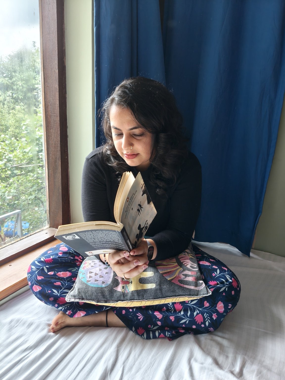 Mahima Kohli reading beside a window